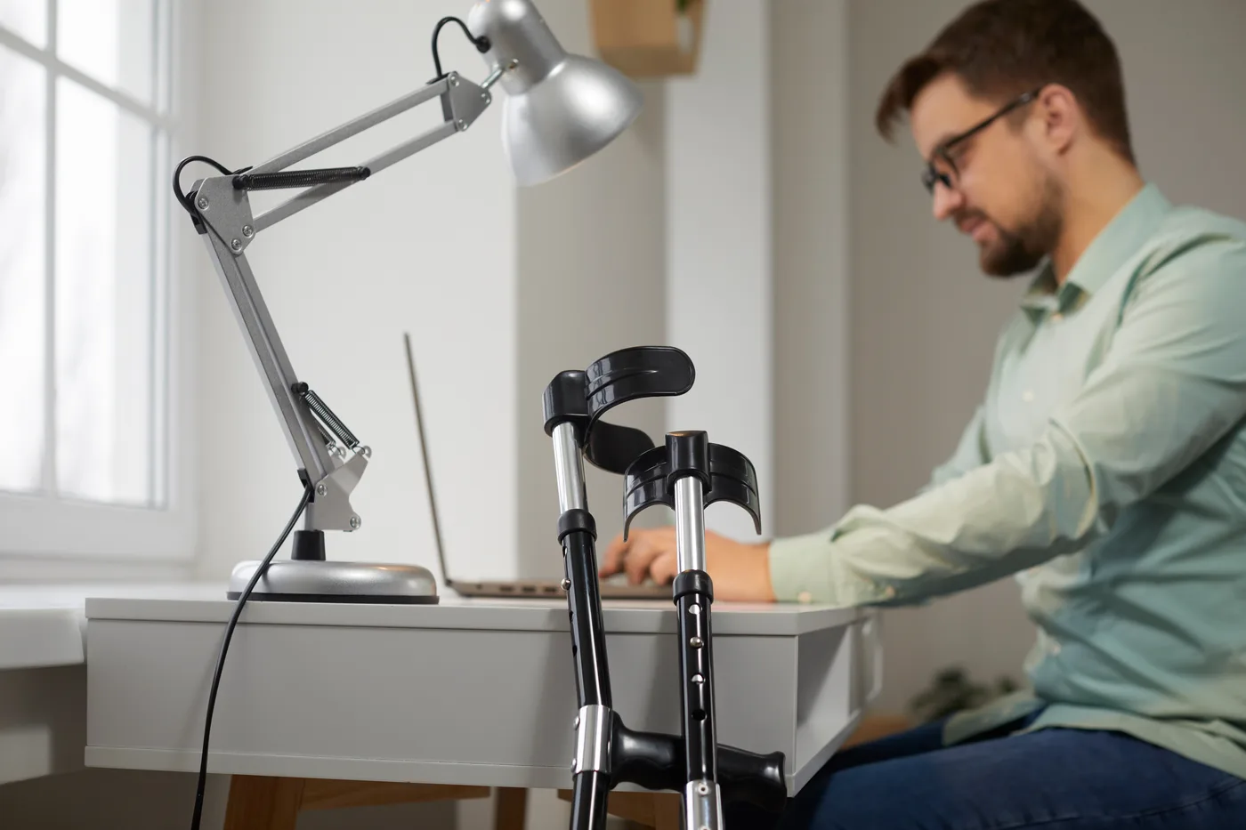 A person with mobility aids working at a desk